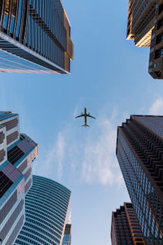 pexels-photo-1157255-1157255 Airplane flies over Chicago's modern skyscrapers against a clear sky, highlighting urban architecture.