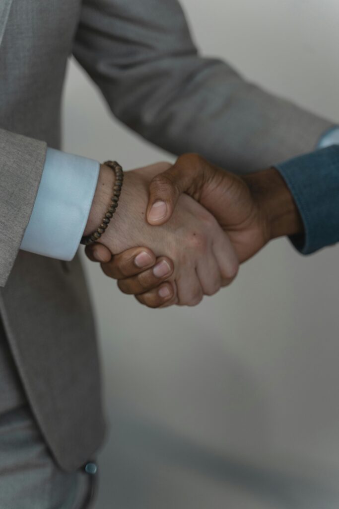 pexels-photo-5439460-5439460 Two business professionals shaking hands, symbolizing agreement and partnership.